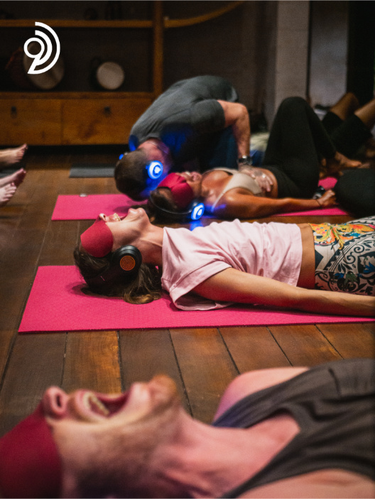 9D Breathwork Session image, from Breathwork Coach in Barrie, with people shown laying on the ground with eyes covered and headphones on screaming