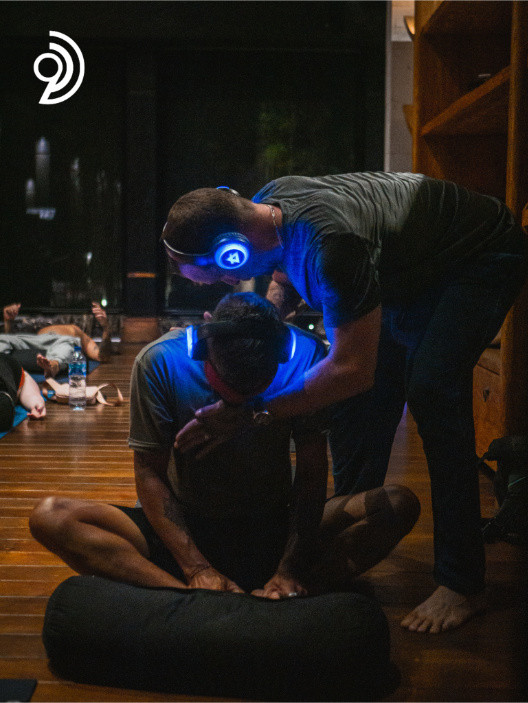 9D Breathwork Session image. from Breathwork Coach in Barrie, with someone holding on to someone elses chest and back as they are in a sitting position with an eye covering on and a headset